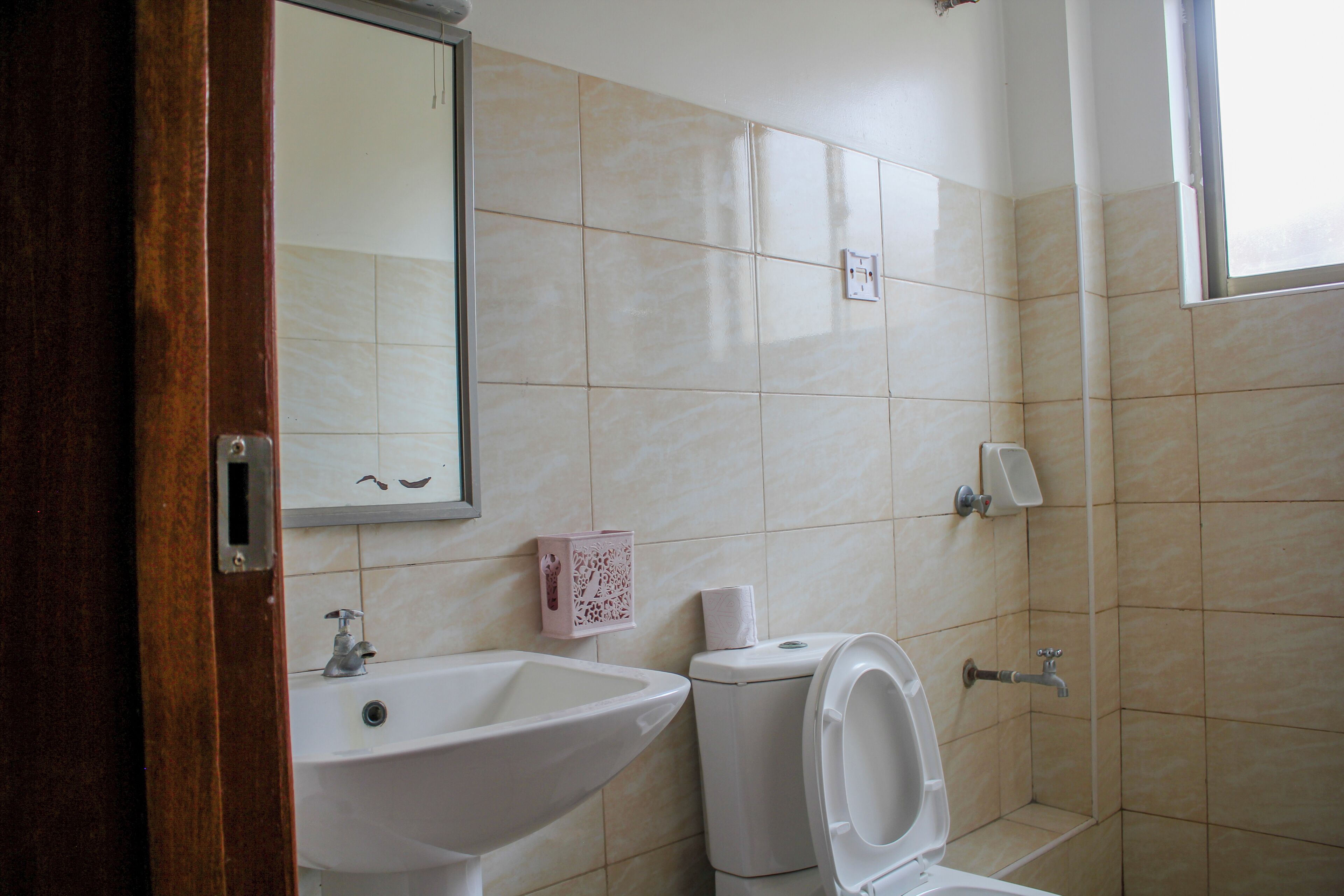 Un baño con lavamanos, inodoro y espejo.