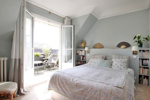 A bedroom with a large bed, a balcony, a bookshelf, and a globe. - Stunning flat with terrasse - Trocadéro (Paris)