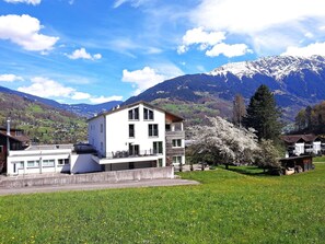 Ein modernes, zweistöckiges Gebäude mit Flachdach, großen Fenstern und einem Balkon.
