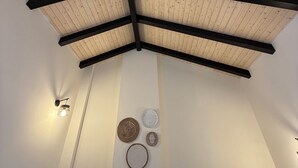 A room with a wooden ceiling, black beams, and wall-mounted light fixtures. - La Corte de Isabel (Cordoba)