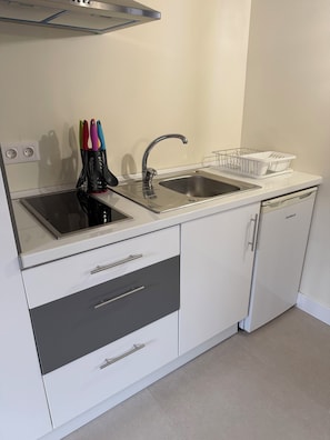 A kitchen with two sinks, a dishwasher, and a countertop with a knife holder.