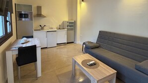 A modern living space with a dining area, a kitchen, and a sofa. - La Corte de Isabel (Cordoba)