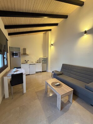 A modern living space with a dining area, a kitchen, and a sofa. - La Corte de Isabel (Cordoba)