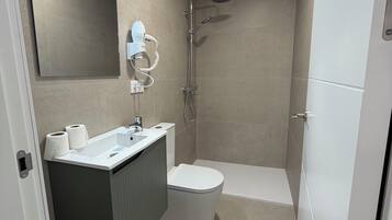 Deluxe appartement | Badkamer | Een douche, handdoeken, zeep, shampoo