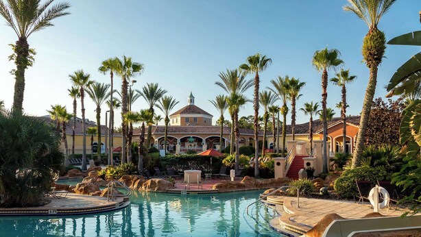 A resort pool with palm trees, a building with a dome, and a staircase. - Casa Palermo At Regal Palms (Davenport)
