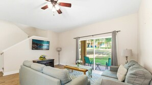 A living room with a sofa, a coffee table, a lamp, and a painting on the wall. - Casa Palermo At Regal Palms (Davenport)