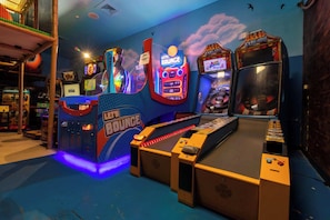 Une salle d’arcade proposant divers jeux, notamment un jeu intitulé « Let’s Bounce », ainsi qu’une table de billard.