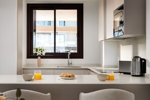 Eine moderne Küche mit Fenster, Spüle, Toaster und Kaffeemaschine.