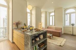 A spacious living area with a marble island, a sofa, and a floor lamp. - Santos Design Townhouse by Cadenzalux (Lisbon)