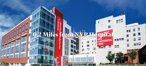 Un edificio moderno con un llamativo cartel rojo y fachada de vidrio.