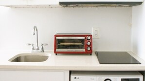Cuina compacta amb microones, torradora, rentatrapesos i rentadora.