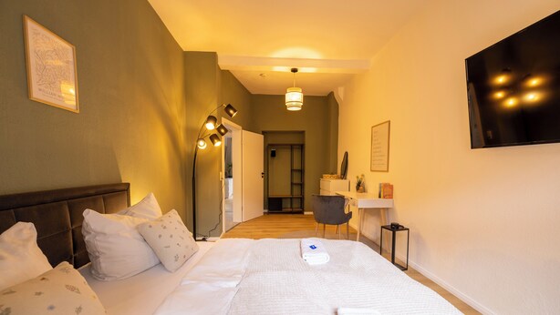 A hotel room with a bed, bedside tables, a desk, and a chair. - City Apartment-River Old Town-central-WLAN- river view (Erfurt)