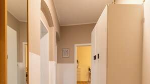 A hallway with a mirror, a wardrobe, and a door leading to another room. - City Apartment-River Old Town-central-WLAN- river view (Erfurt)