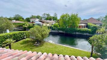 A residential area with a canal, houses, and greenery.