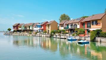 A row of colorful houses by a calm water body with boats docked.