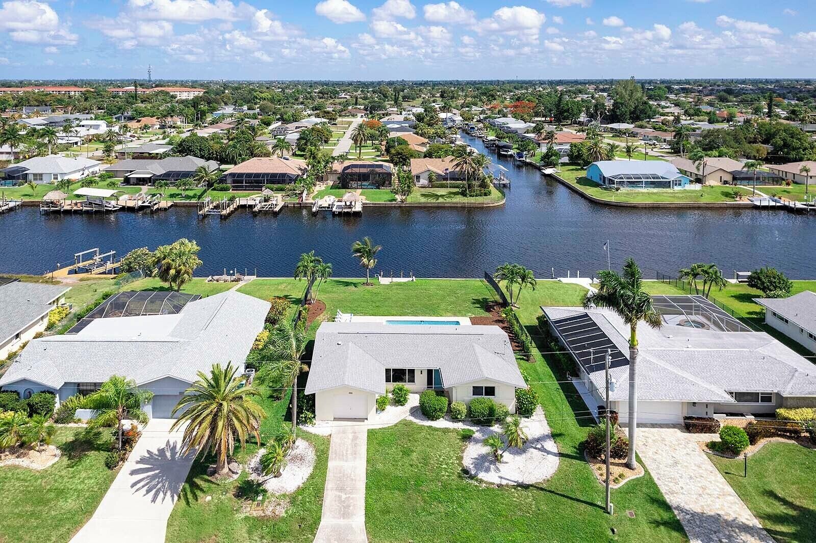 A residential area with houses, a canal, and a dock with boats.