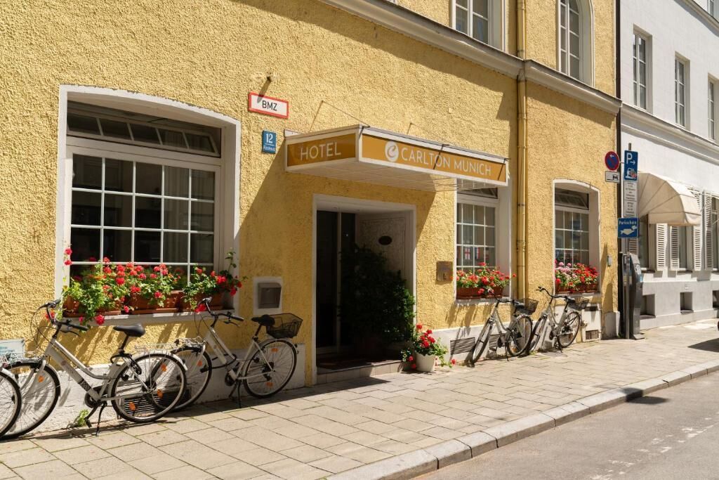 Un hotel con fachada amarilla, un cartel que indica que es hotel y bicicletas estacionadas afuera.
