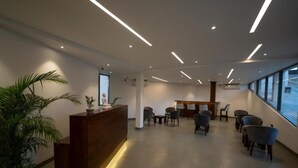 A reception area with a wooden desk, several chairs, and a large window providing a view. - Iris - Kandy (Kandy)