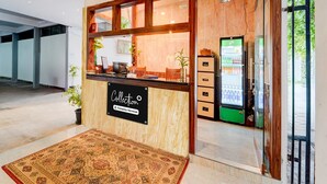 A reception area with a wooden counter, a sign reading 'Collection,' and a refrigerator. - Super Collection O Vazhakkala Kakkanad (Kanayannur)