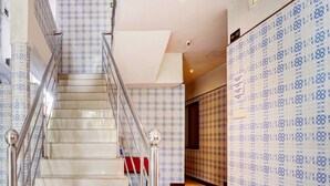 A staircase with patterned walls and a metal railing. - Super Collection O Vazhakkala Kakkanad (Kanayannur)