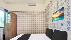 A hotel room with a bed, patterned wallpaper, a window with curtains, and a painting on the wall. - Super Collection O Vazhakkala Kakkanad (Kanayannur)