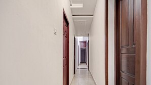 A hallway with a door on the left, a door on the right, and a light fixture on the ceiling. - Super Collection O Vazhakkala Kakkanad (Kanayannur)
