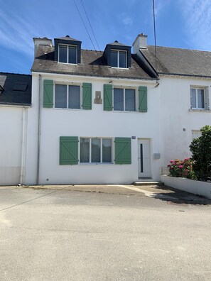 A two-story building with a white facade, green shutters, and a small porch area. - MAISON DE KERNERS (Arzon)