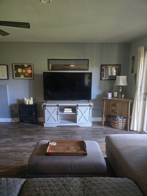 A living room with a flat-screen TV, a fireplace, a sofa, and a coffee table. - Walk to downtown Twain Harte from this cozy studio with EV charger. (Twain Harte)