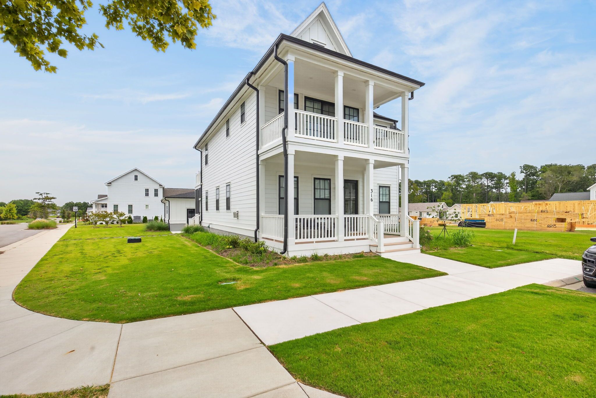 A two-story house with a front porch and a well-maintained lawn.