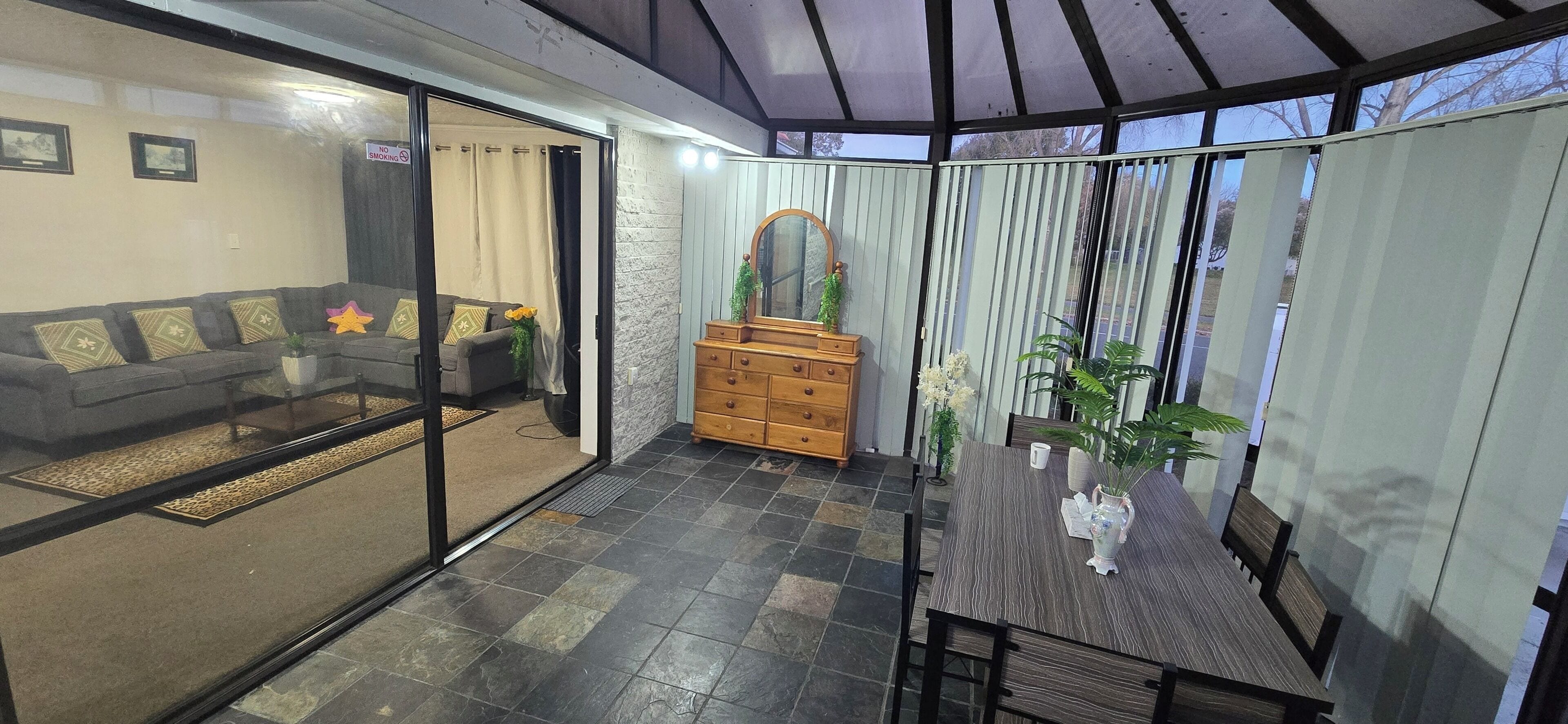 A modern living room with a sofa, a wooden dresser, and a dining table with chairs.. Modern 2BR Home, Sleeps 5,  Parking,  Near Eastgate
