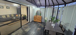 Ein modernes Wohnzimmer mit einer Couch, einer Holzkommode und einem Esstisch mit Stühlen.