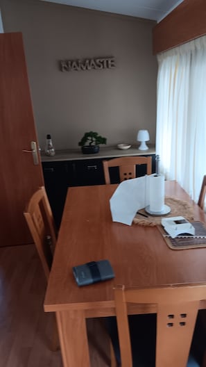 Ein Essbereich mit Holztisch, Stühlen, einer Lampe und einem kleinen Topfpflanzen.