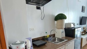 A modern kitchen with a built-in stove, a sink, and a small countertop area. - Cozy condo Near Roxas Night Market (Davao City)