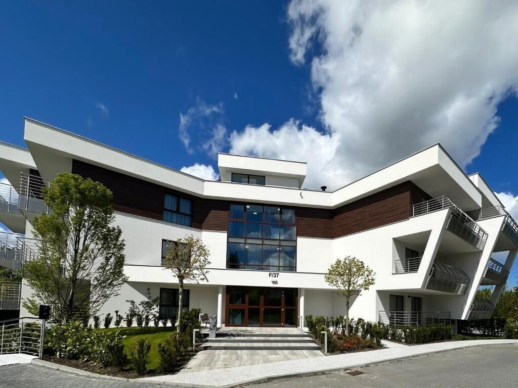 Un edificio moderno con un diseño angular distintivo, una entrada central y cielo despejado.