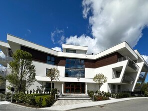 Un edificio moderno caratterizzato da un design angolare originale, un ingresso centrale e un cielo sereno.