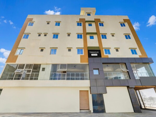 A multi-story building with a sign reading 'TOWNHOUSE.' - Deluxe Hennur Prakruthi Layout Bangalore (Bengaluru)