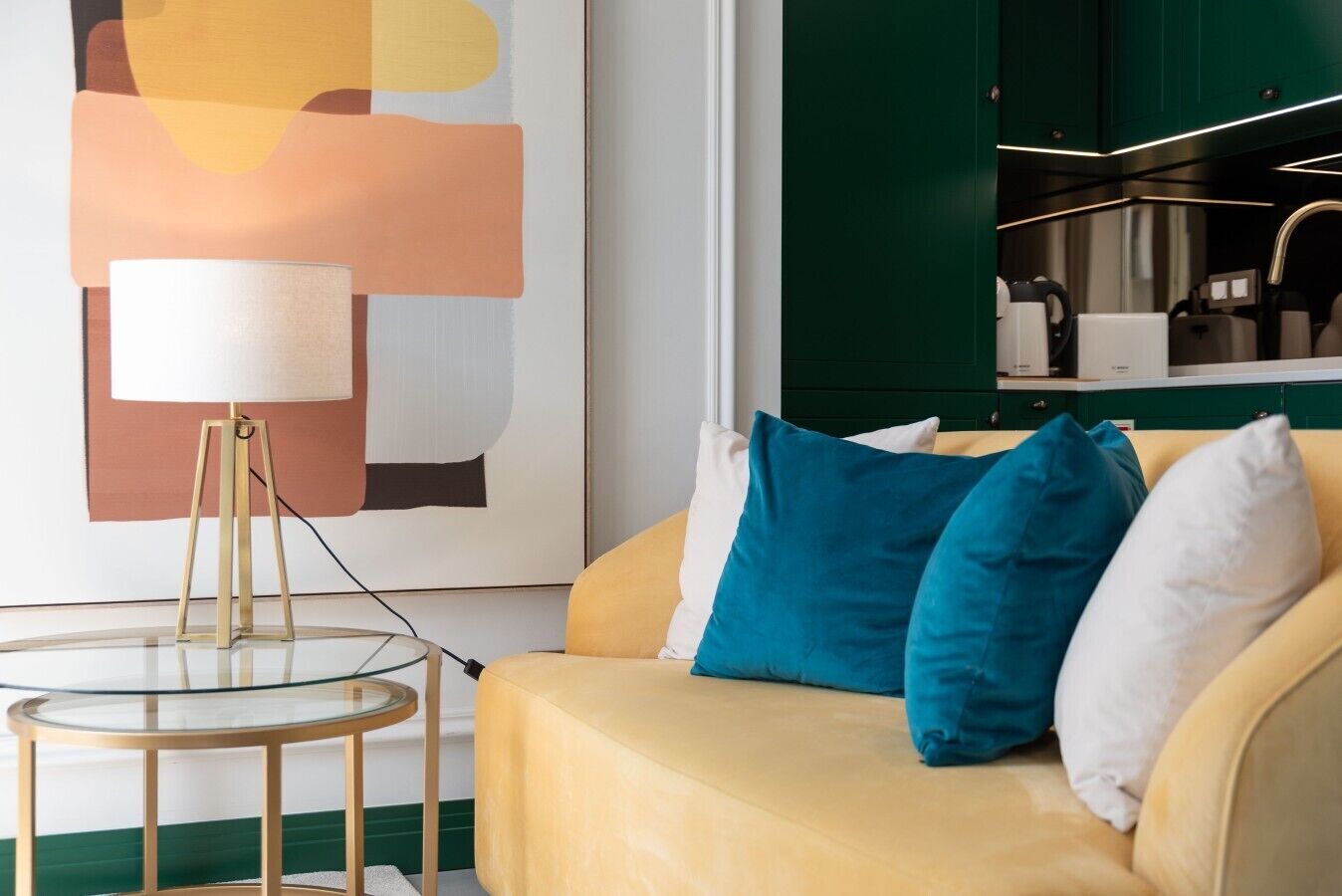 Een moderne woonkamer met een bank, een glazen tafel en een lamp.