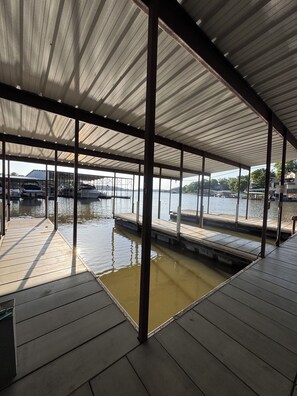 A covered dock area with a view of the water and distant buildings. - Best Location and view on the Lake! 3 pools! Minutes to Pool bars & The Strip! (Osage Beach)