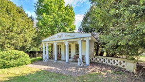A white pavilion with columns, surrounded by trees and a gravel path. - Finest Retreats | The Pottage (Oakley)
