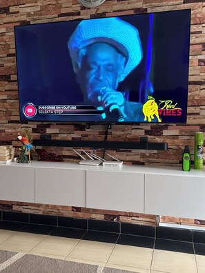 Ein Flachbildfernseher an einer Wand mit einem dekorativen Steinmuster.