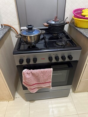 Eine Küche mit Herd, Backofen und einem Topf auf dem Herd.