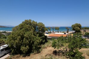 A coastal area with a beach, trees, and a parked RV. - Sun Beach Apartment in Chania 14 (Chania)