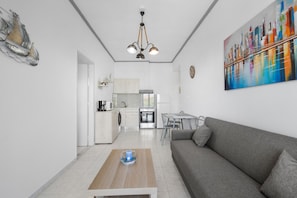 A modern apartment with a living room, kitchen, and dining area. - Sun Beach Apartment in Chania 14 (Chania)