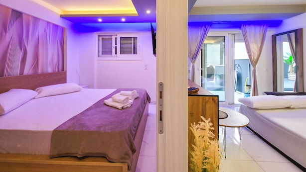 A hotel room with a bed, a small table, and a view of the outside. - 3 - ILEKTRA Suite by SDR (Paralia)