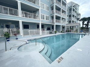 A multi-story hotel with a swimming pool, balconies, and outdoor seating. - Grand Caribbean 214 • Fully Renovated • Walk to Beach• Sleeps 6 (Orange Beach)