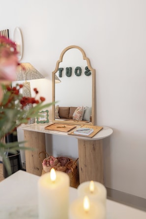A room with a vanity, candles, a mirror, and a small basket of rolled towels. - Sout Huijs Langebaan - A little slice of West Coast Heaven with Hot Tub (Langebaan)