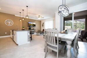 A spacious kitchen with a dining area, a ceiling fan, and a large window providing natural light. - Water View & Beachside Mickey NEAR Disney 2637 (Kissimmee)