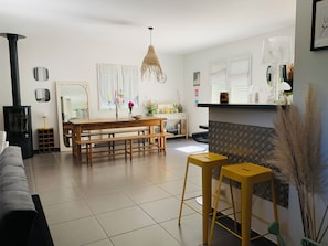 Un salon moderne avec une cheminée, une table à manger, des bancs et un canapé.