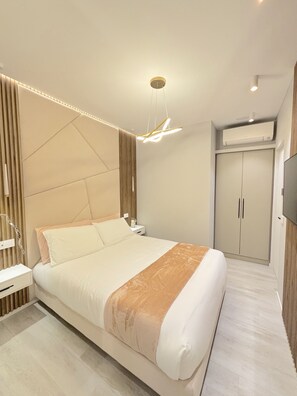 Ein modernes Schlafzimmer mit Bett, Nachttisch und Kleiderschrank.