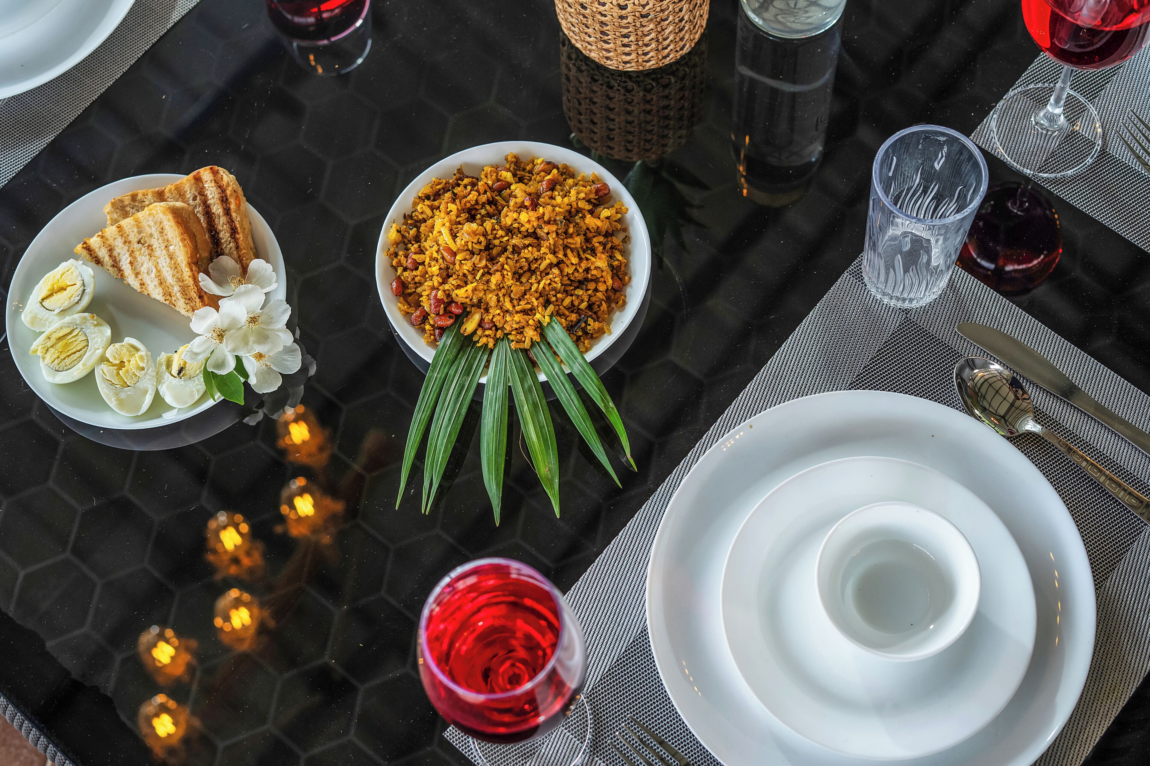 Una mesa dispuesta con platos, tazones y vasos, indicando una disposición para comer.